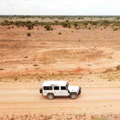 White four-wheel drive (4WD) vehicle on an open dirt road in outback Australia.