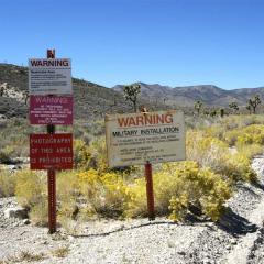 An image of military warning signs along the side of a road at Area 51 near Rachel, Nevada.