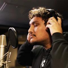 An image of Jamaine Wilesmith (aka Durriwiyn) in the recording studio wearing headphones and singing into a microphone.