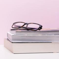 Stack of two books with eye glasses on top.