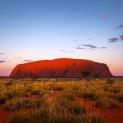 An image of the sun setting over Uluru.