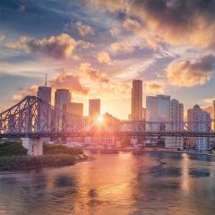 Cityscape image of Brisbane skyline, Australia with Story Bridge during dramatic sunset.