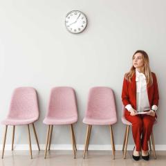 A young woman sitting in a foyer waiting for a job interview.