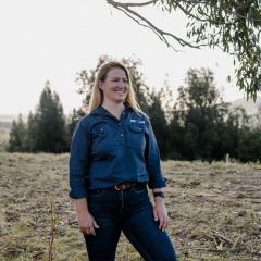 Jess Pattison wearing a Dirt Lab shirt and standing in a paddock.