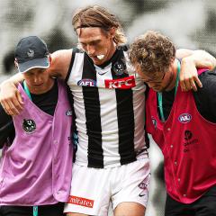 Collingwood defender Nathan Murphy is helped from the field.