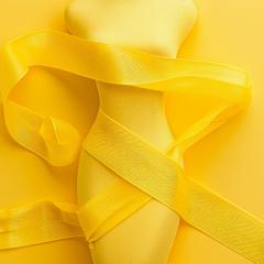 Endometriosis awareness concept with female body and yellow ribbon on a yellow background.