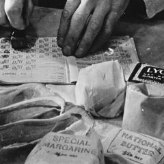 An old photograph of war rations and a pair of hands filling in a record-keeping journal