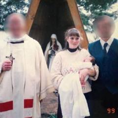 An image of Claire Ashman holding one of her children at a baptism. 