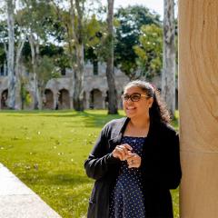 An image of Journalist and UQ alum Rhianna Patrick with UQ's Great Court in the background.