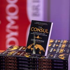 An image of copies of the The Consul, written by Ian Kemish and published by UQP. 