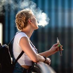 An image of young woman vaping.