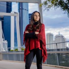 An image of UQ researcher Dr Astrid Rodriguez-Acevedo standing on the Kurilpa Bridge in Brisbane.