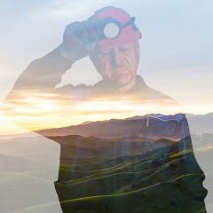 A miner overlaid over a scenic background.
