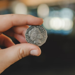 Image of two fingers holding a silver 50c coin