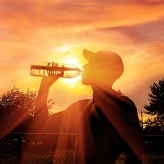 Man drinking water during heatwave.