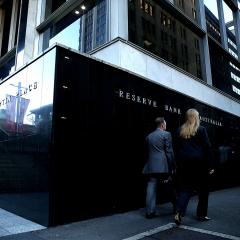 Pedestrians walk past the Reserve Bank of Australia headquarters.