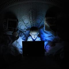 boy playing at laptop inside room