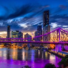 An image of Brisbane and the Story Bridge lit up at night time.