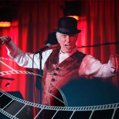 An image of the legendary entertainer Dick Van Dyke performing on stage.