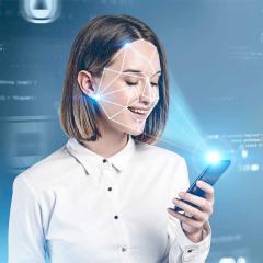 Young woman with phone, using face recognition