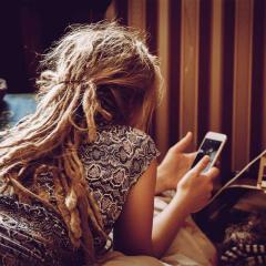 An image of a woman scrolling on her mobile phone