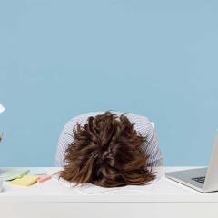 A woman with her head on a desk