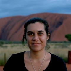 An image of Indigenous journalist and UQ PhD student Amy McQuire in front of Uluru