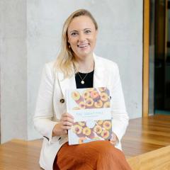 A photo of Michelle Grant holding her book 'The Great Full'.