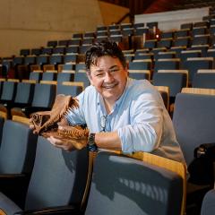 An image of UQ PhD candidate Tim Richards holding a replica of a pterosaur skull