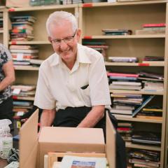 An image of Book group volunteer Robert Bourke sorting through books..